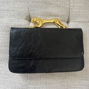Black clutch with a gold tiger handle